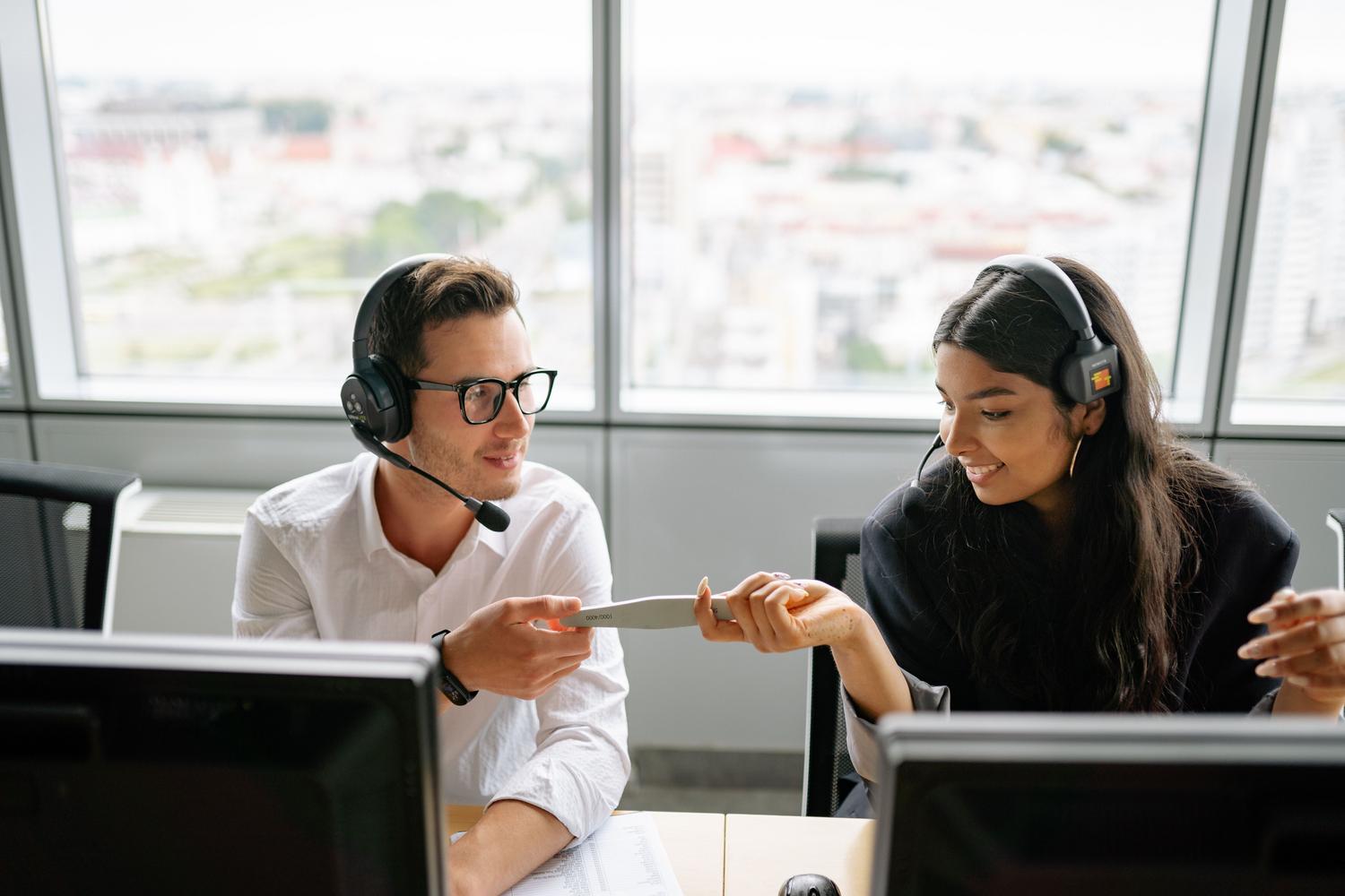 Dos agentes de ventas colaborando en la gestión de leads y notas internas para mejorar la experiencia del cliente.