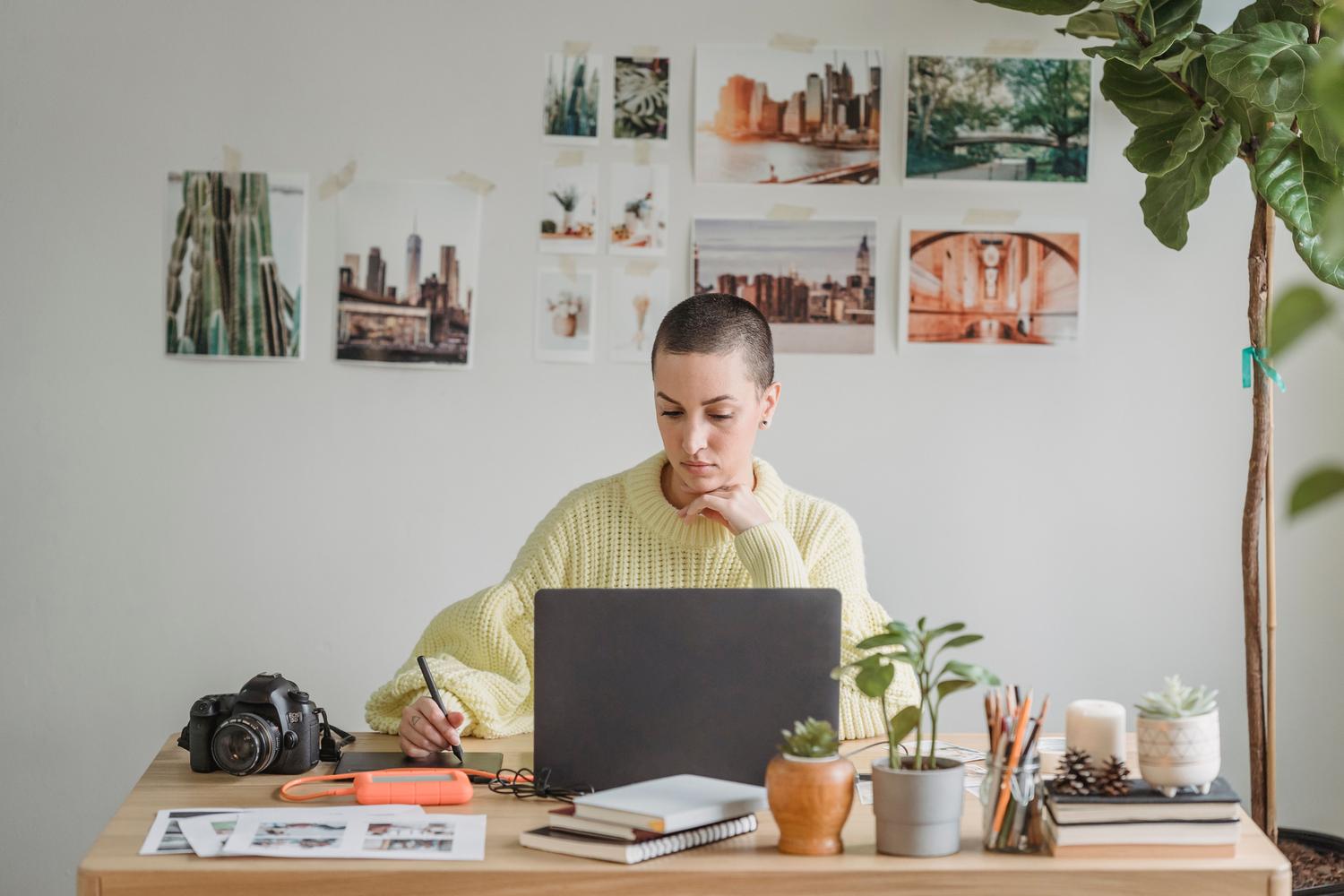Mujer concentrada diseñando en una tablet gráfica, representando la profesionalidad y el detalle en la creación de activos digitales.