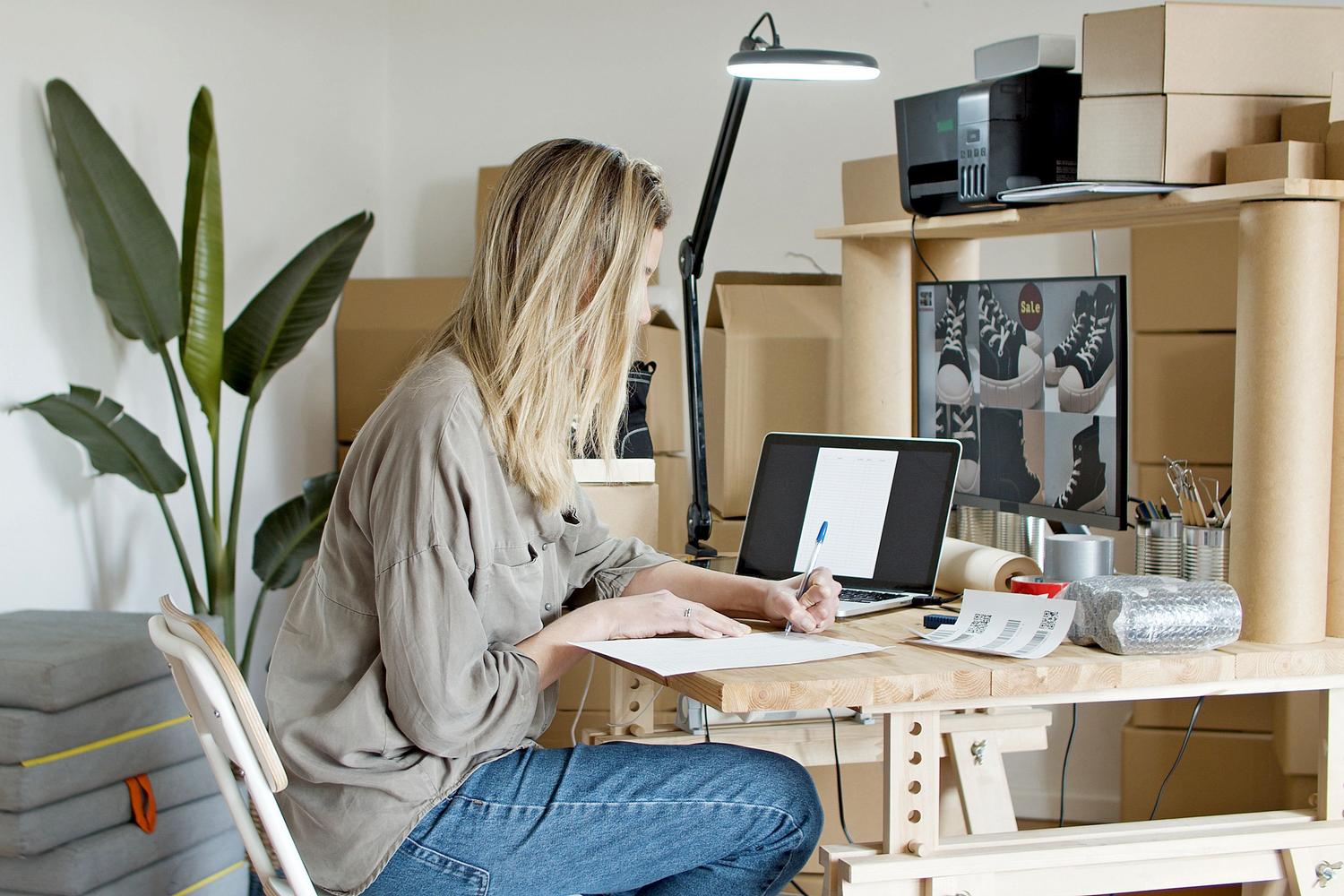 Emprendedora gestionando su negocio de productos digitales desde la comodidad de su oficina en casa.