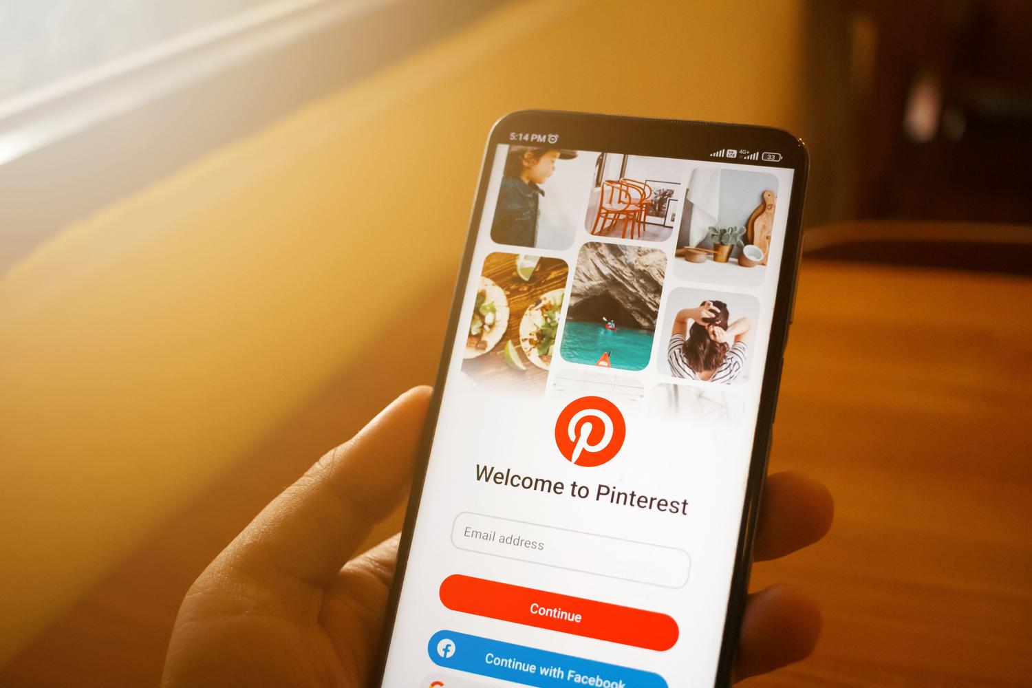 Persona utilizando la aplicación de Pinterest en su móvil para gestionar una cuenta empresarial.