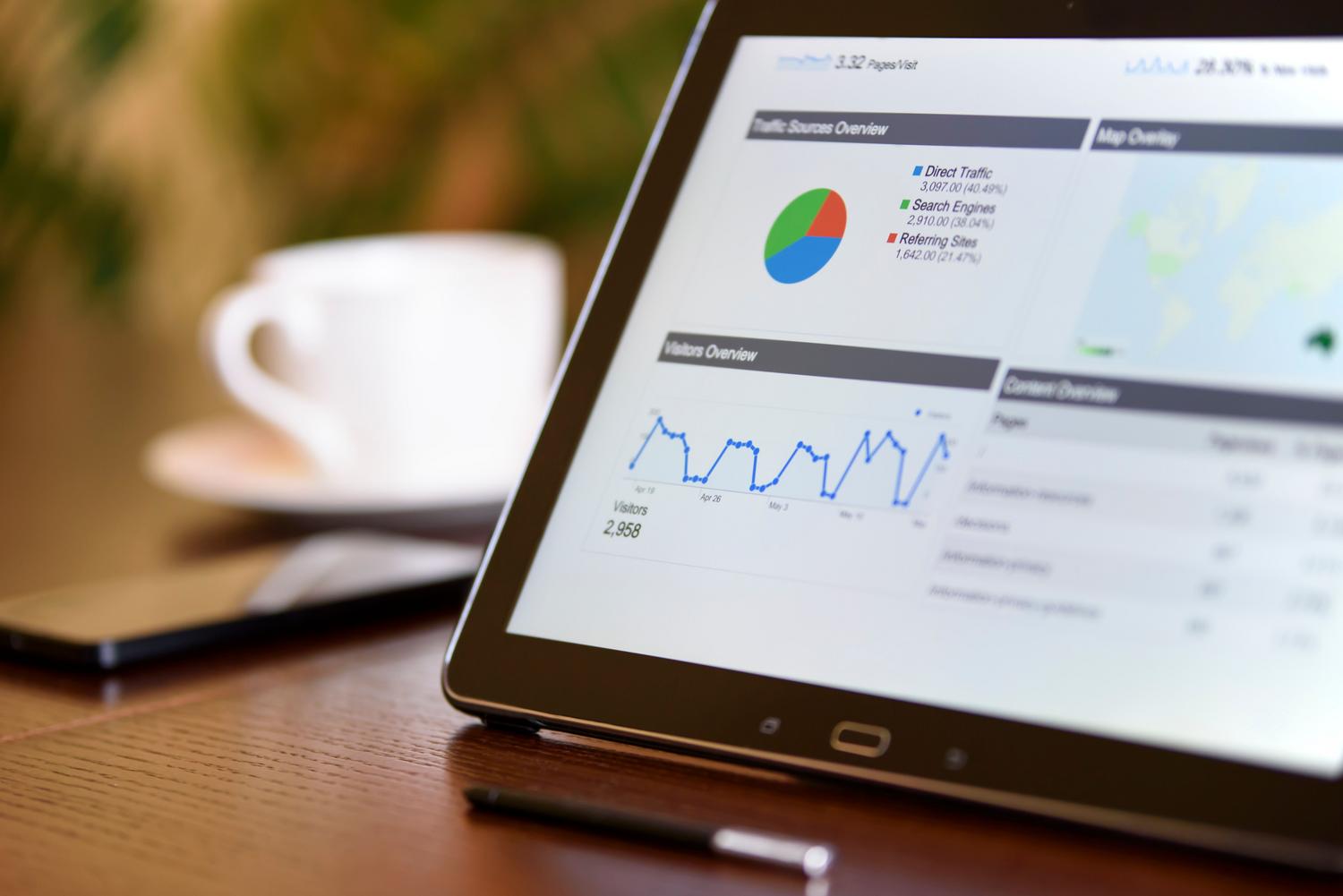 Tablet y smartphone sobre escritorio mostrando analíticas en tiempo real, representando la movilidad y agilidad del equipo comercial.