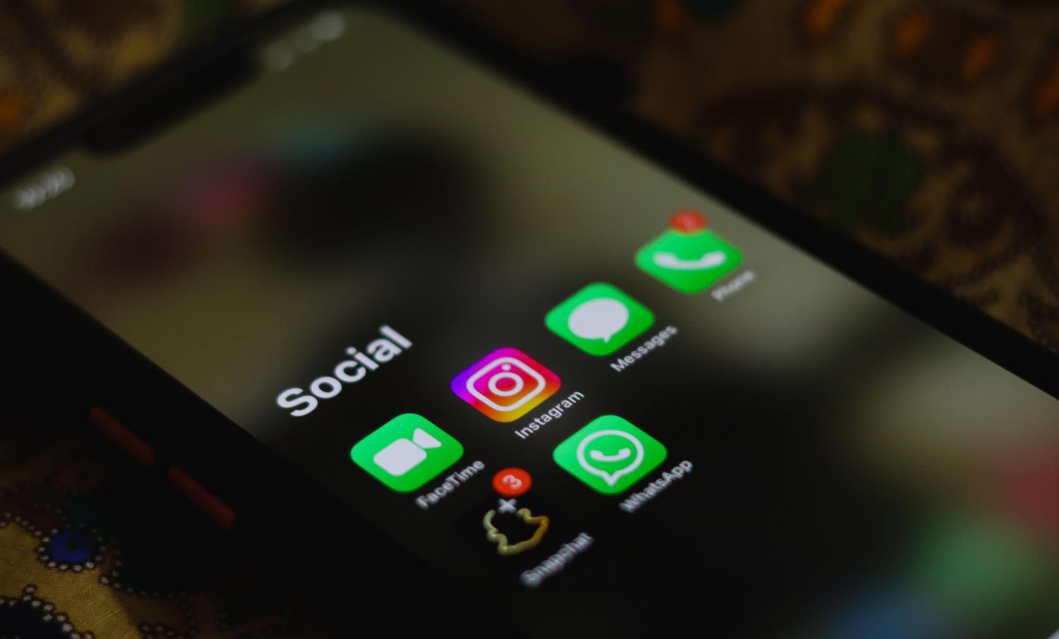 Smartphone mostrando diversas aplicaciones de redes sociales, ideal para la creación de anuncios creativos en Facebook e Instagram.