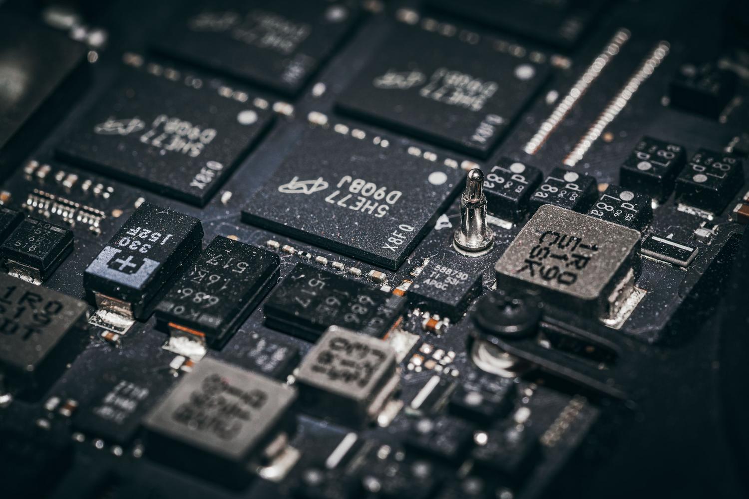 Primer plano de microchips en una placa de circuito, ilustrando el hardware donde se instala el firmware.