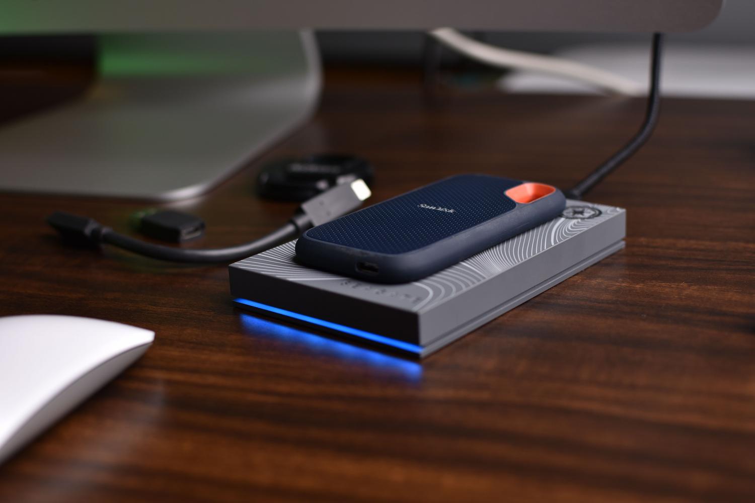 Unidades SSD externas portátiles de alta gama sobre un escritorio de madera limpio.