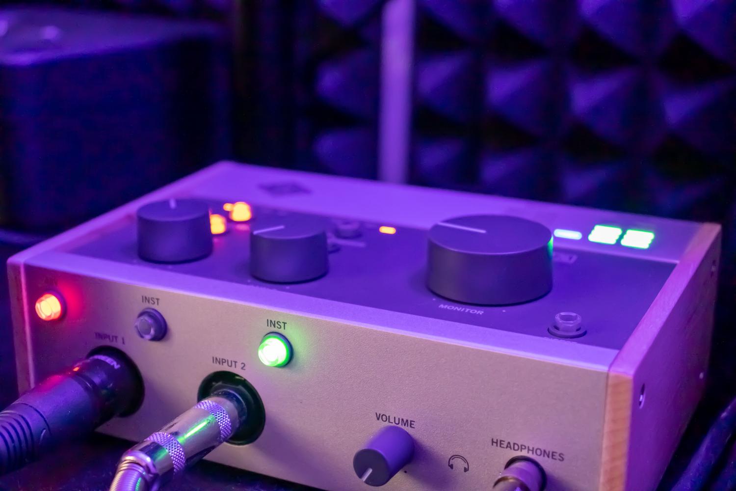 Detalle técnico de una interfaz de audio con entradas XLR, cables conectados y luz de alimentación Phantom +48V activada. Detalle técnico de una interfaz de audio con entradas XLR, cables conectados y luz de alimentación Phantom +48V activada.