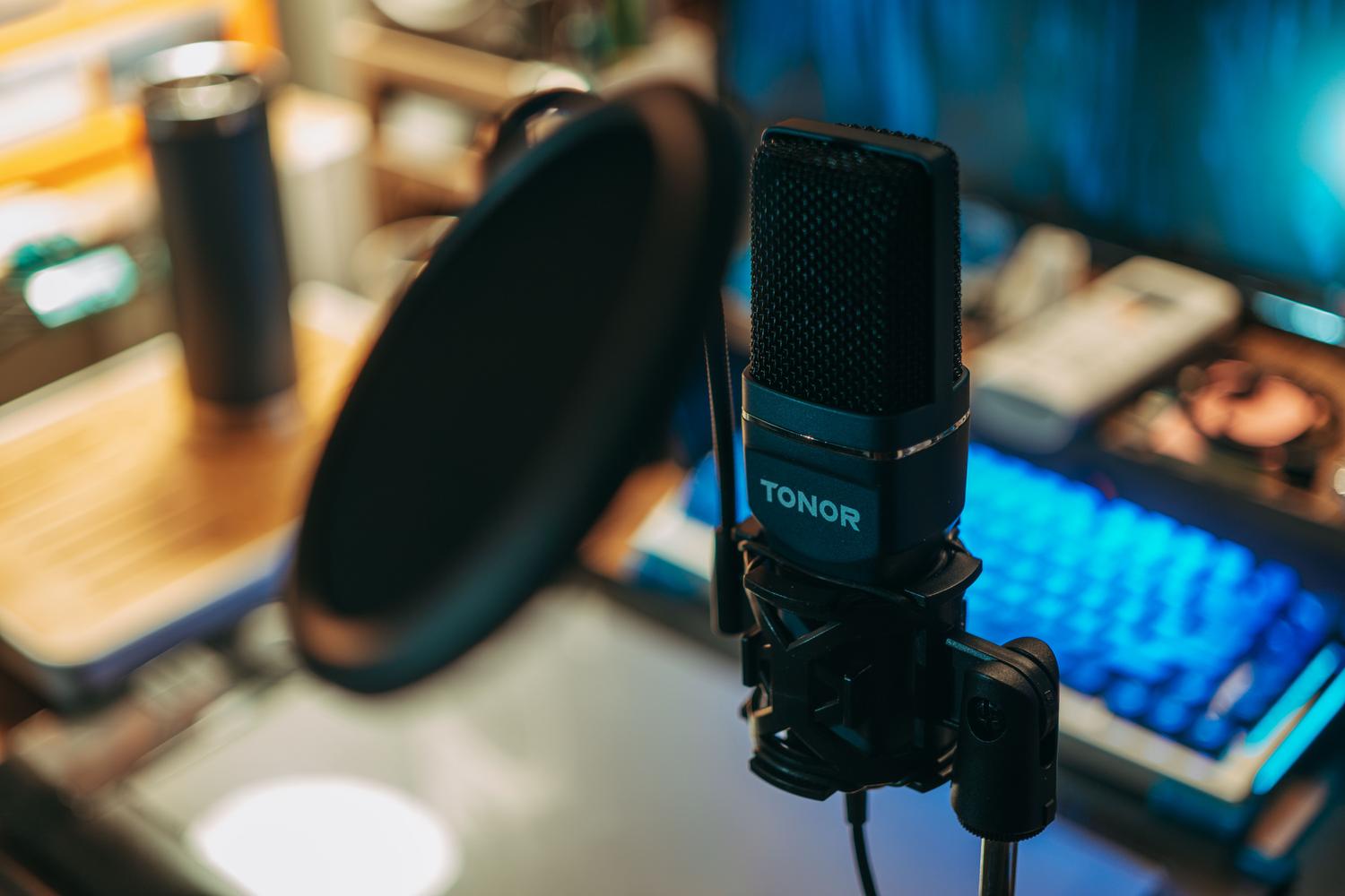 Micrófono de estudio con filtro anti-pop sobre un escritorio de grabación