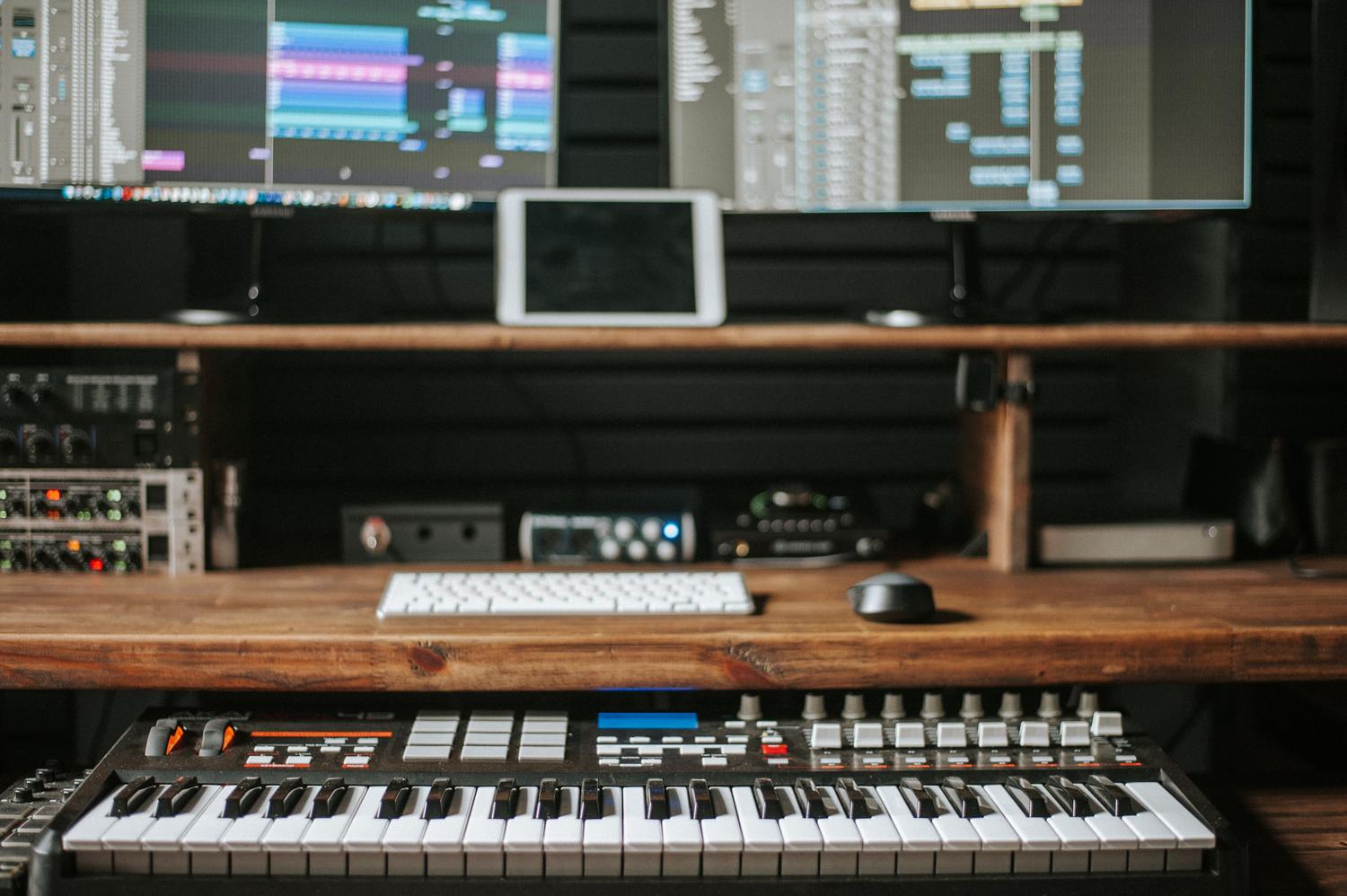 Configuración profesional de producción musical con monitores y equipo de rack, mostrando la complejidad de la cadena de señal.