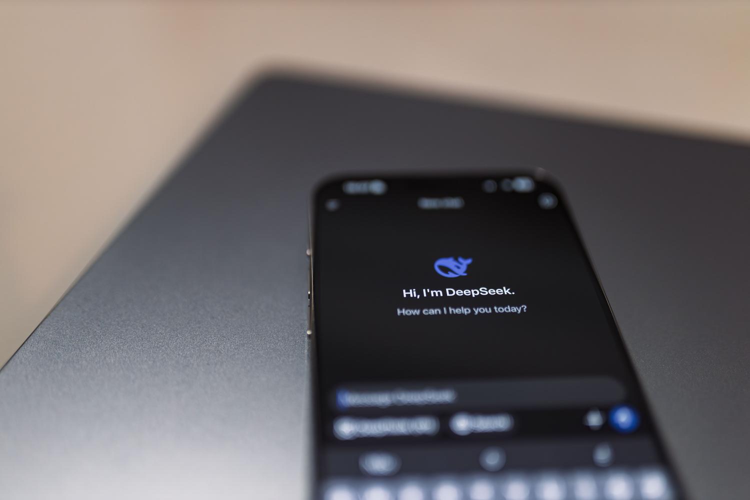 Smartphone con asistente de IA colocado sobre un ordenador portátil, simbolizando la multimodalidad y la versatilidad de las IAs en diferentes entornos de trabajo.