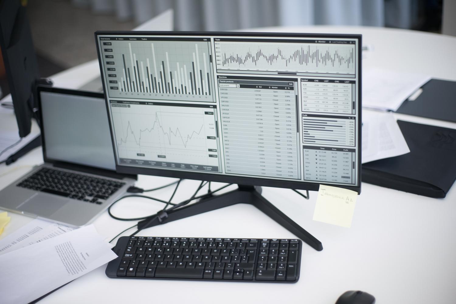 Entorno de trabajo profesional con monitor mostrando dashboards de análisis de datos masivos