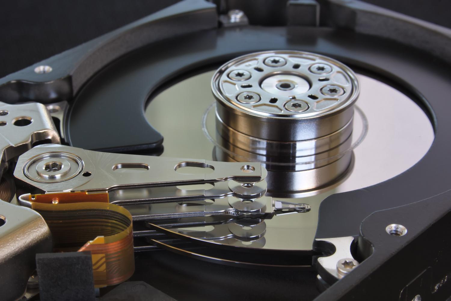 Primer plano de un disco duro abierto, representando el almacenamiento físico tradicional frente al backup en la nube.