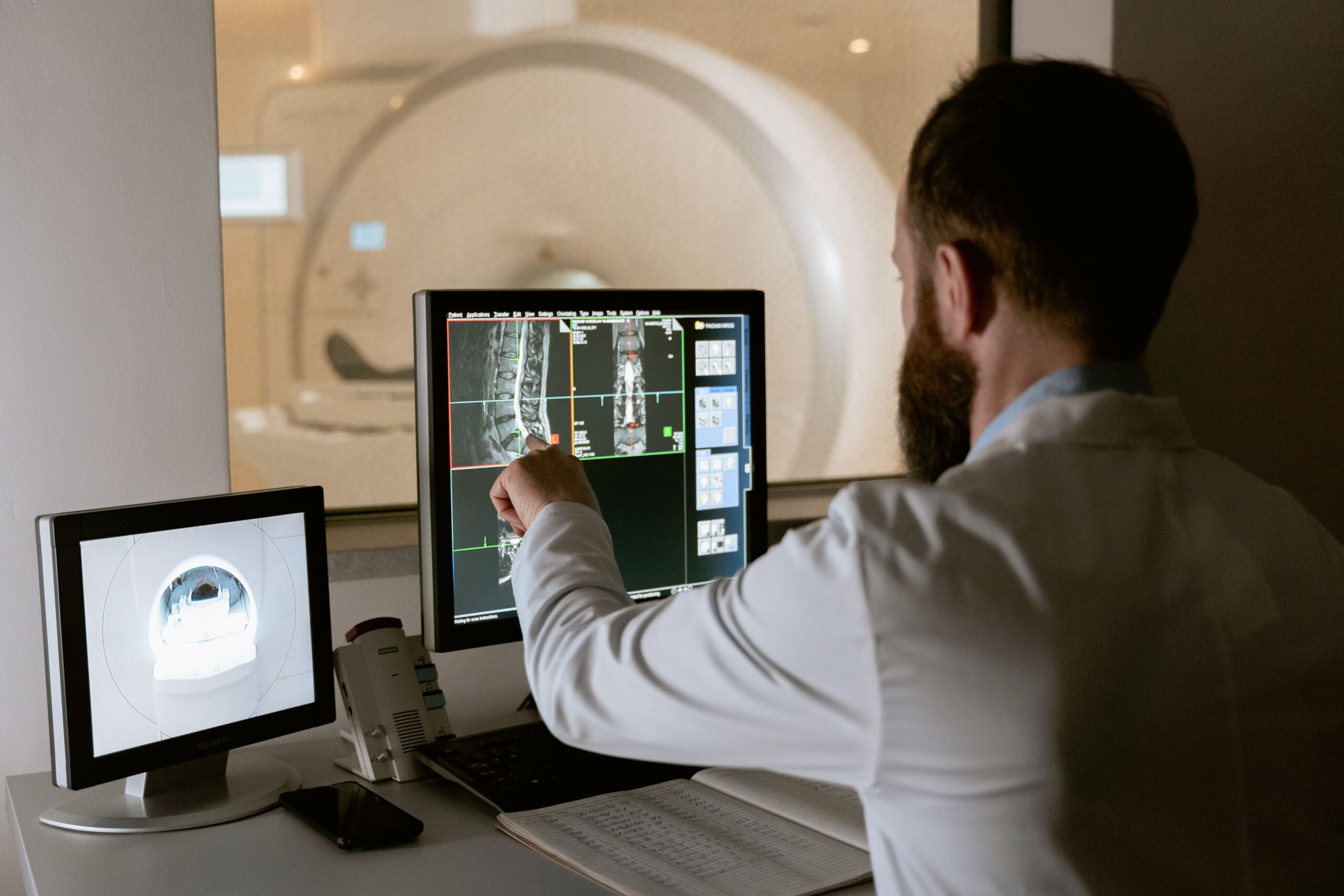 Profesional médico supervisando el proceso de resonancia magnética y analizando los resultados en tiempo real