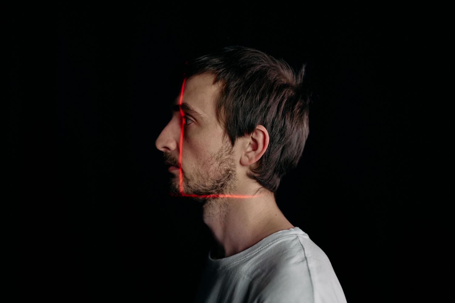 Perfil lateral de un hombre con líneas de escaneo láser, representando la capacidad de la IA para la detección facial en ángulos no frontales.
