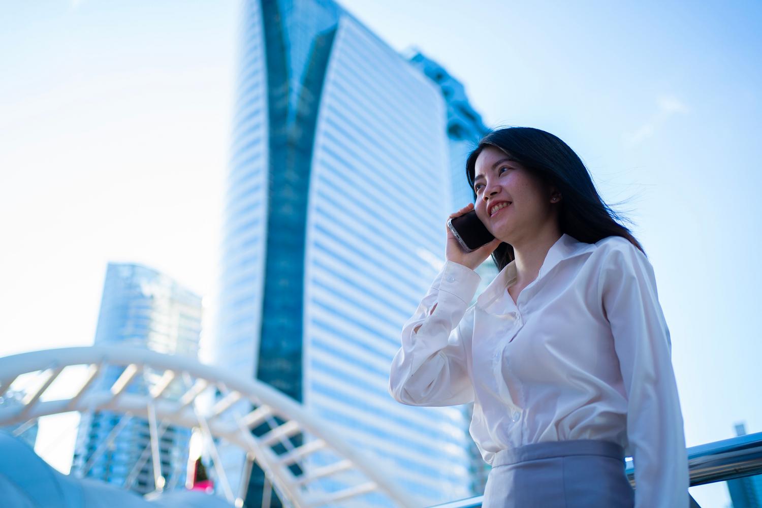 Mujer de negocios profesional en Bangkok con rascacielos de fondo, ideal para ilustrar servicios de traducción en mercados asiáticos.