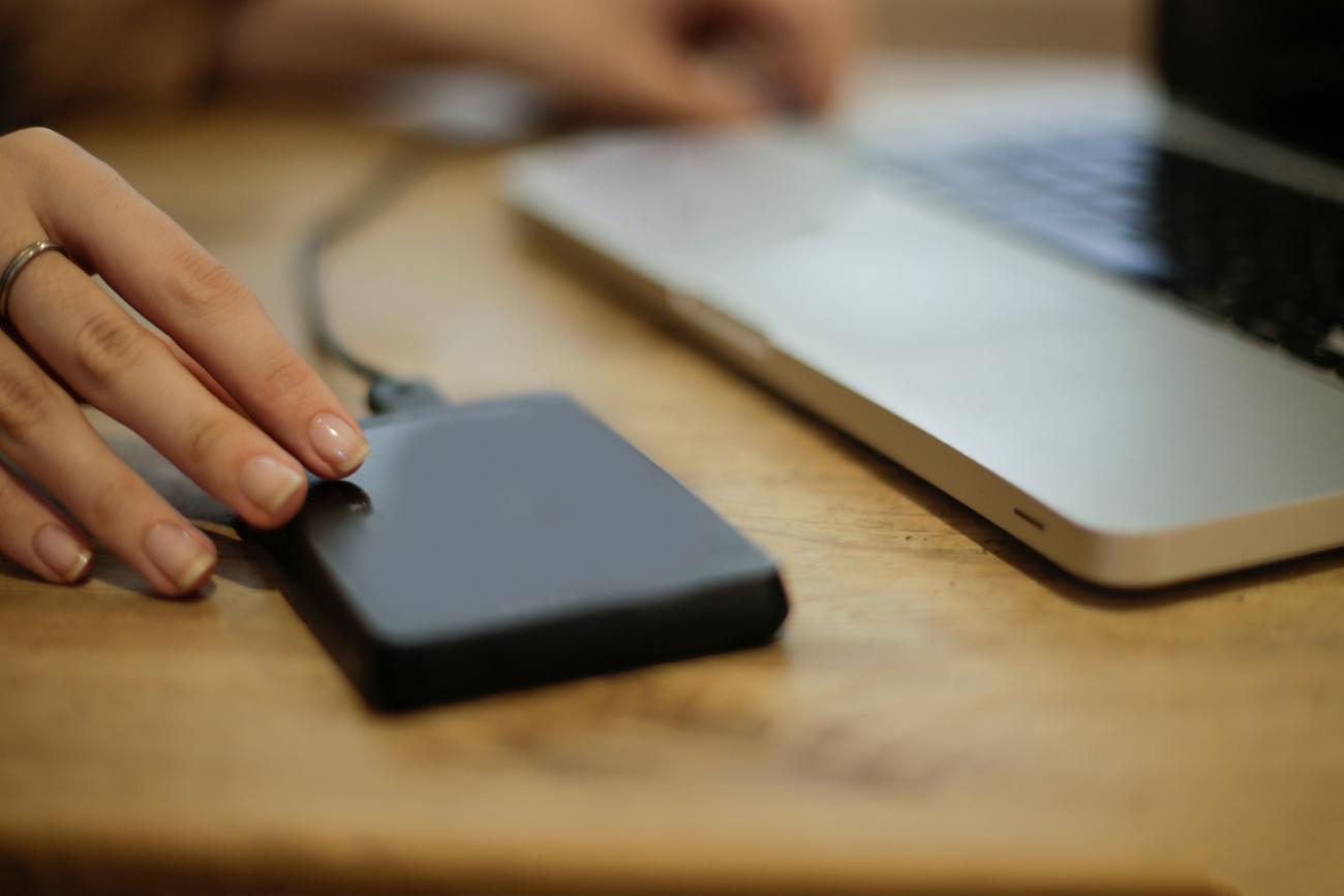 Primer plano de la conexión de un disco duro externo a un ordenador para respaldo de datos local.
