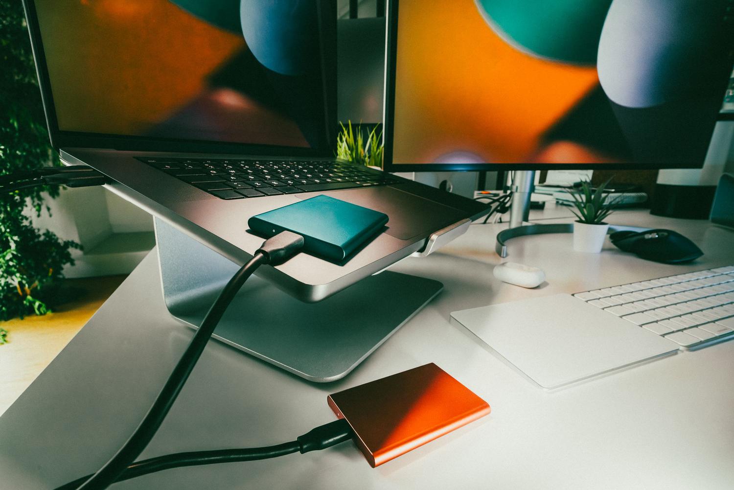 Espacio de trabajo moderno con ordenador y unidades de almacenamiento para copias de seguridad.