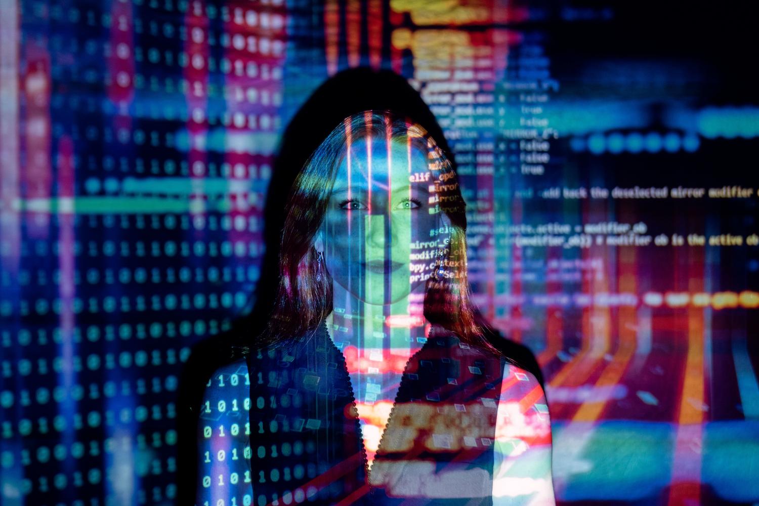 Retrato artístico de una mujer con proyecciones de código digital sobre su rostro, representando el lado curioso y experimental de los lenguajes de programación.