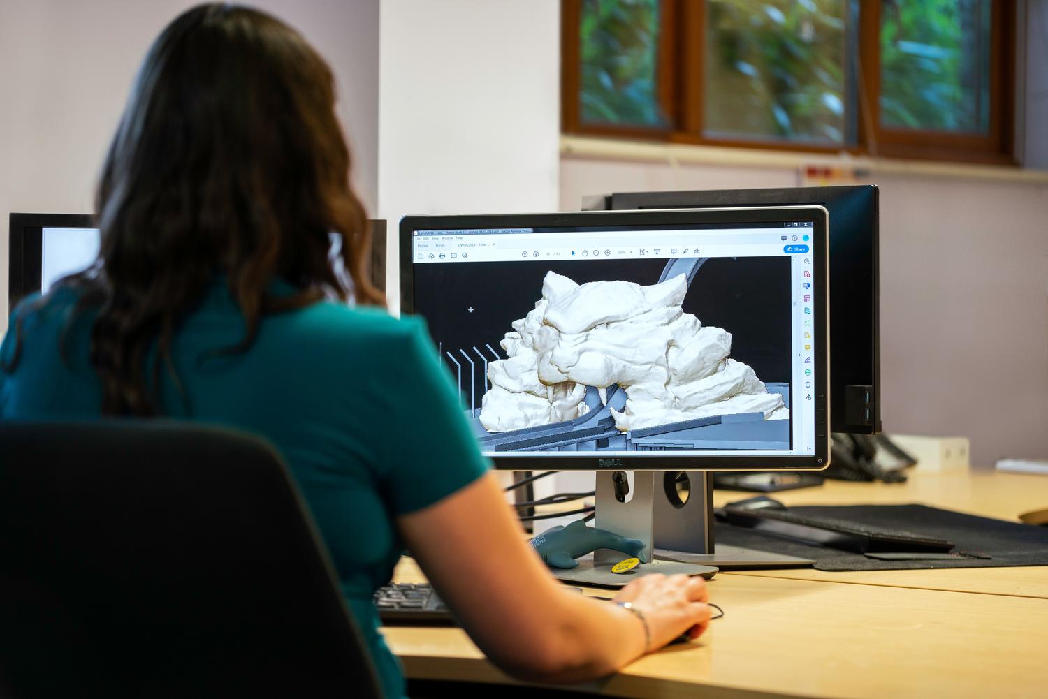 Profesional utilizando software de modelado 3D en una estación de trabajo de diseño técnico
