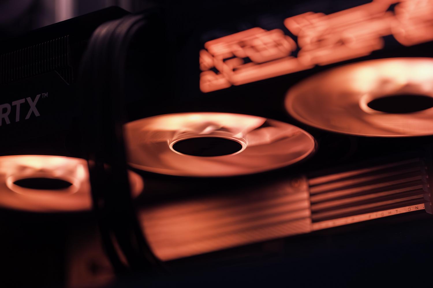 Detalle de los ventiladores de una tarjeta gráfica gaming con iluminación roja, destacando la importancia de la refrigeración para el rendimiento.