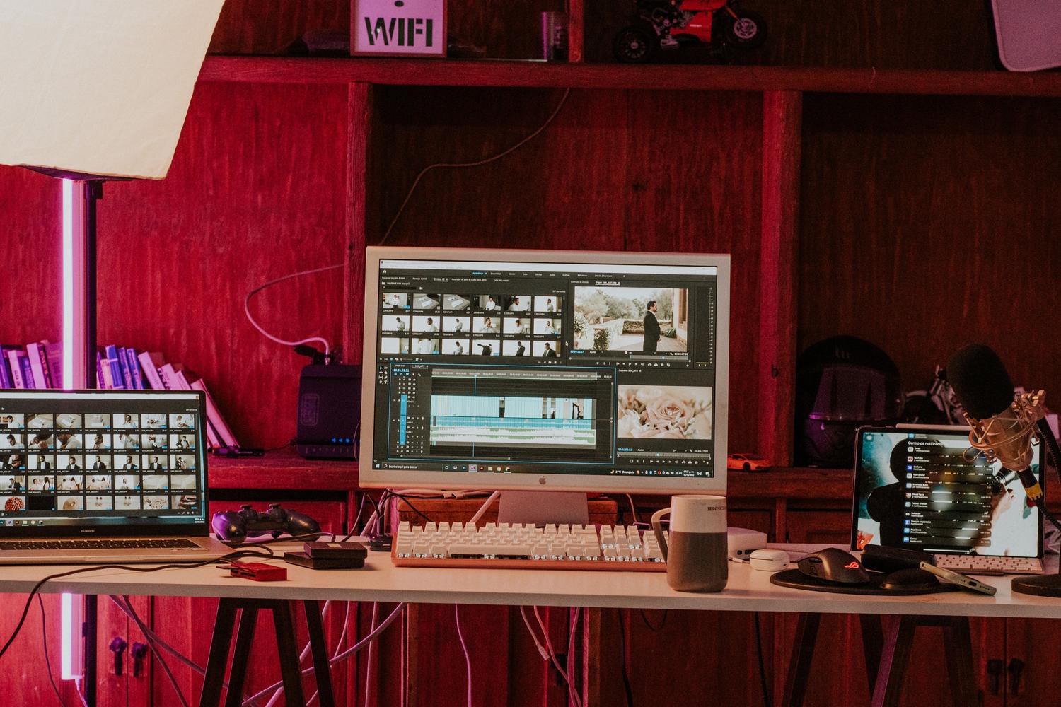 Estación de trabajo profesional de edición de vídeo y color con múltiples monitores y equipamiento de estudio.