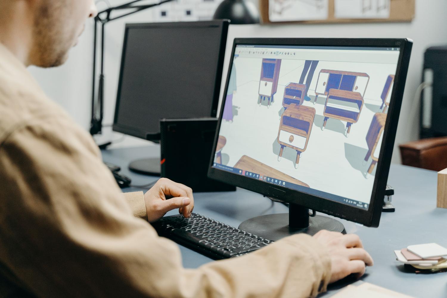 Diseñador profesional utilizando software de modelado 3D en una estación de trabajo optimizada.