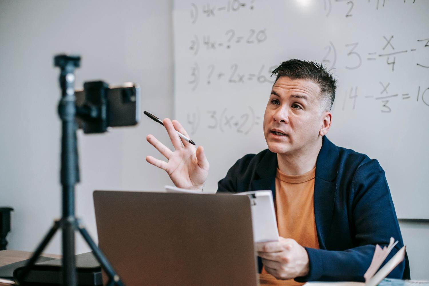 Profesor impartiendo una clase online mediante webcam, ejemplificando el uso profesional de herramientas de streaming.