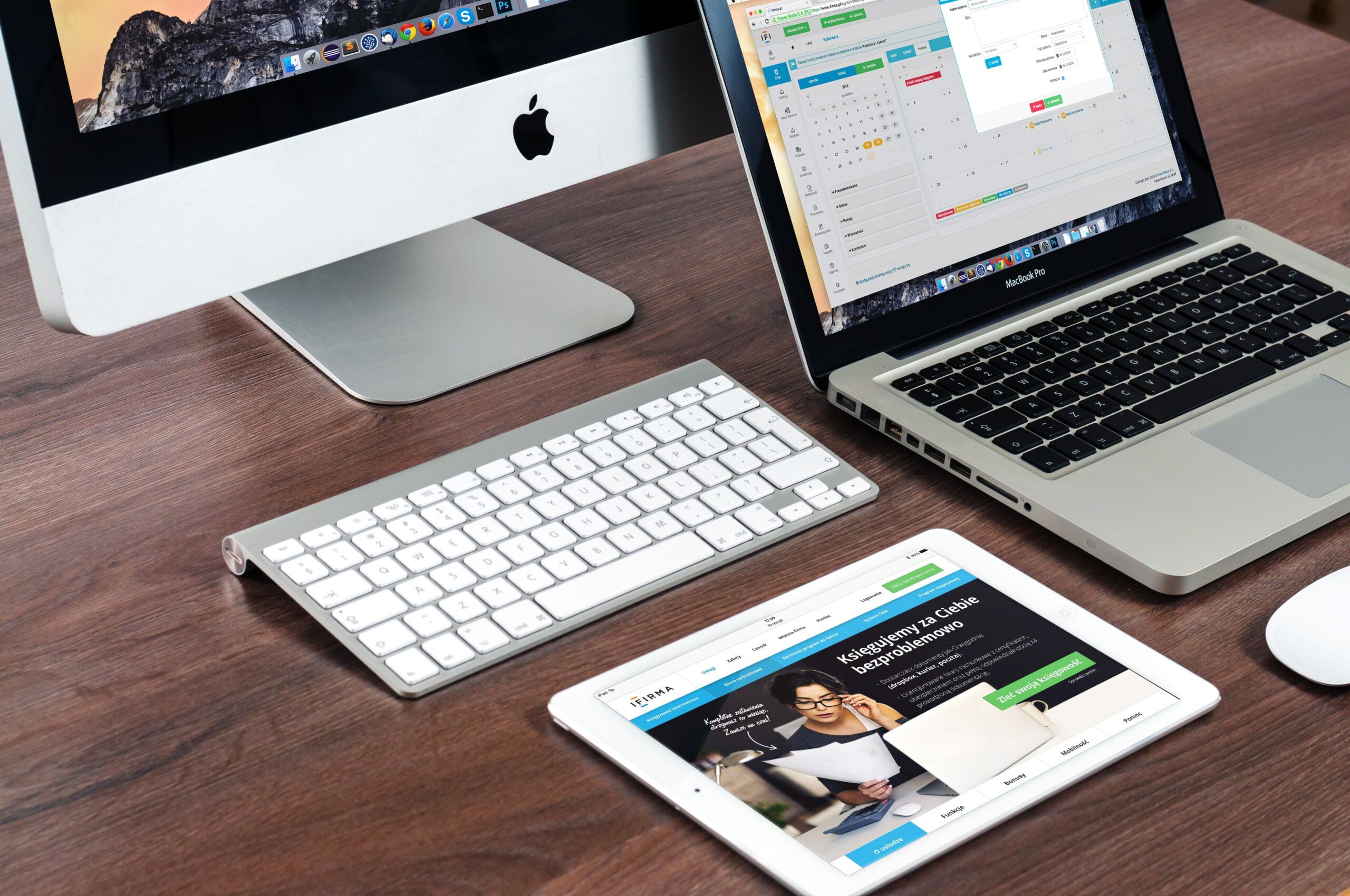 Conjunto de dispositivos Apple, incluyendo iMac y MacBook, sobre un escritorio de oficina minimalista