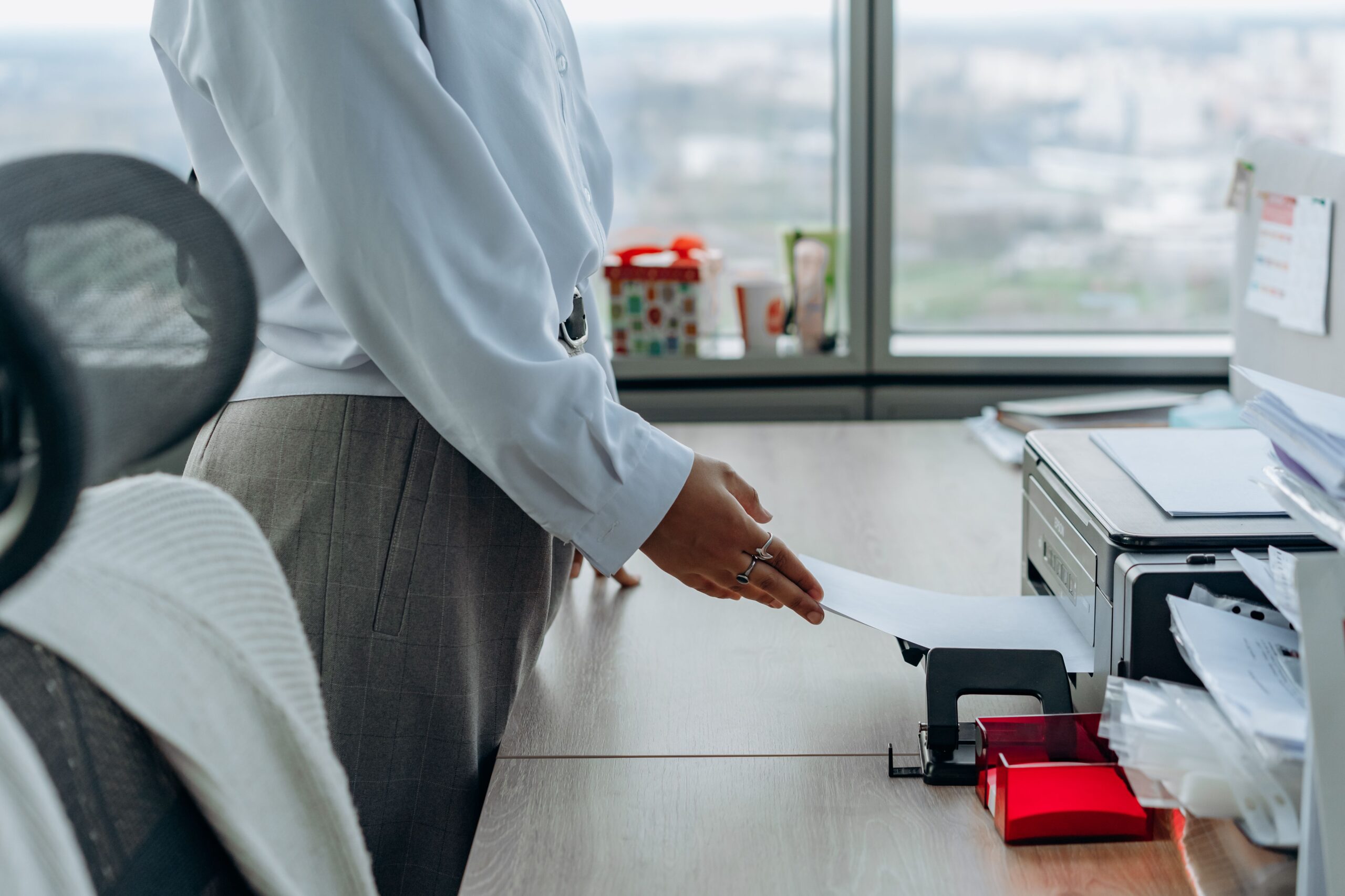 Profesional de negocios imprimiendo un documento en un entorno de oficina corporativo