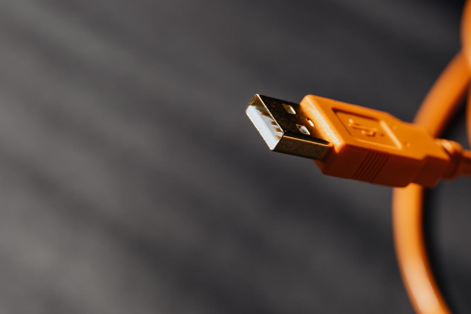 Primer plano de un conector de cable USB, resaltando la interfaz física de conexión.