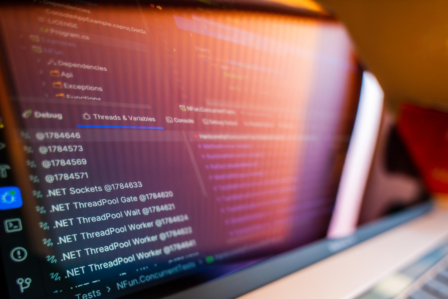 Primer plano de una pantalla de ordenador mostrando código de programación y procesos de depuración de errores