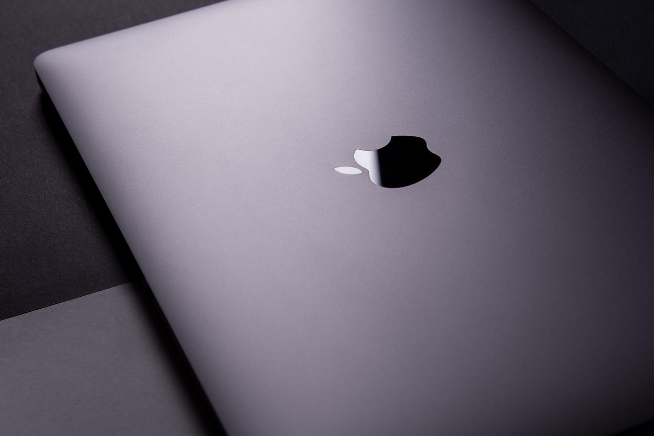 Vista elegante de un MacBook moderno sobre un fondo oscuro, representando el sistema operativo macOS