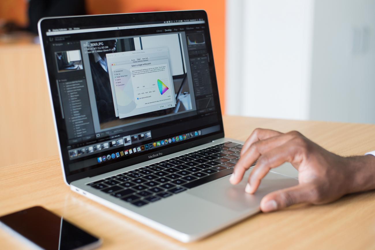 Profesional utilizando un MacBook en un entorno de oficina, ilustrando el uso optimizado del sistema