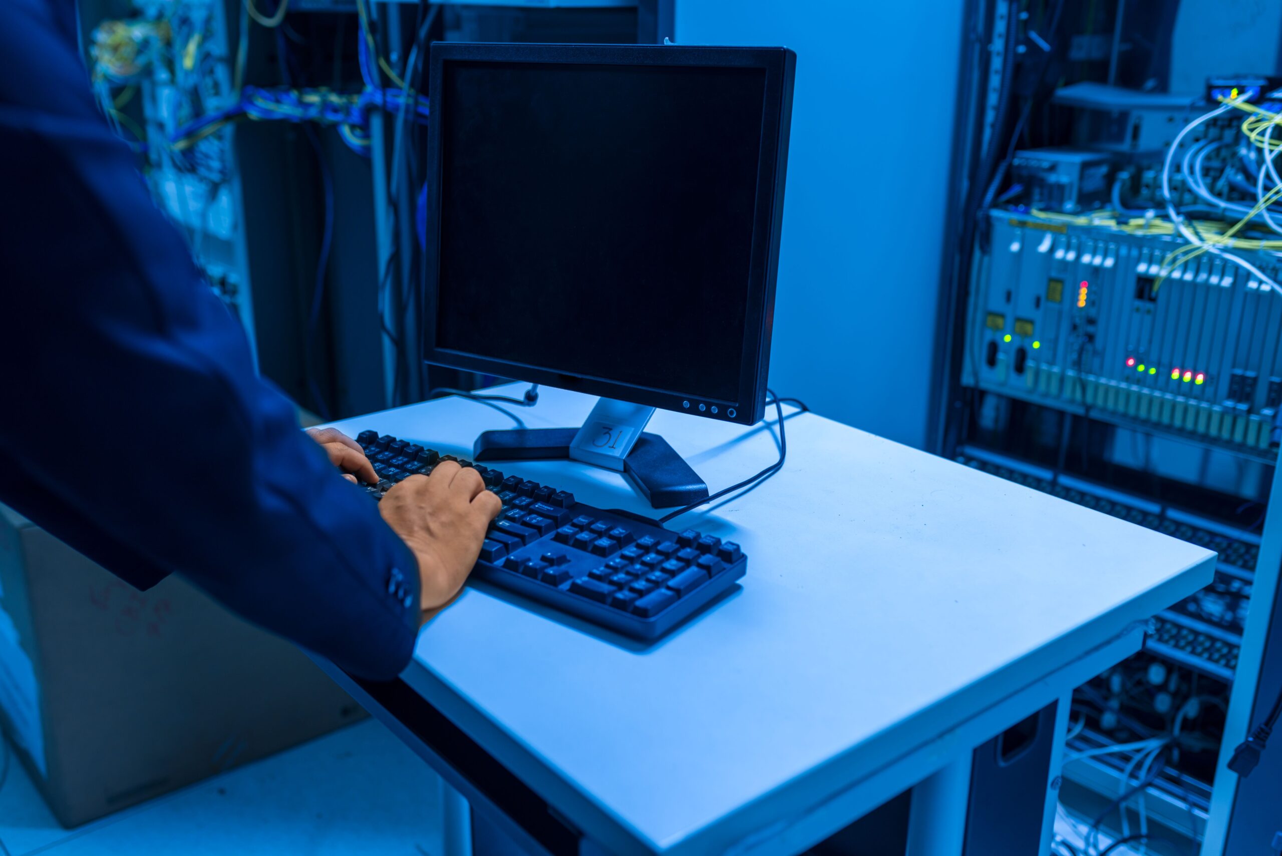 Administrador de sistemas configurando equipos en una sala de servidores