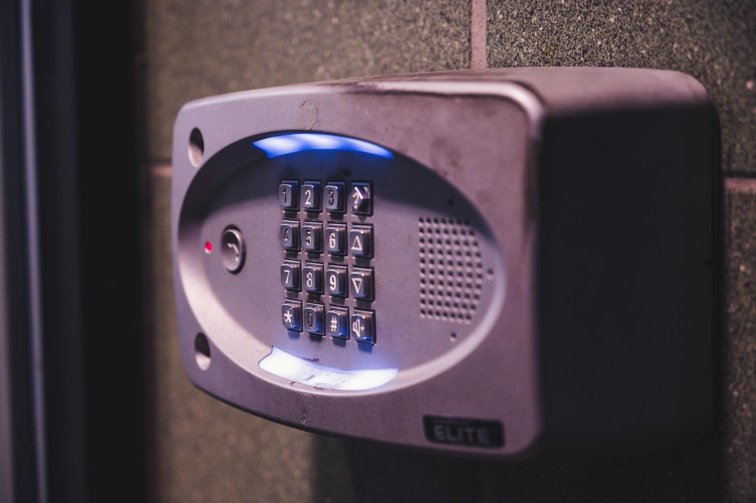 Teclado de seguridad iluminado en una pared, metáfora visual del control de acceso y la autenticación en sistemas digitales.
