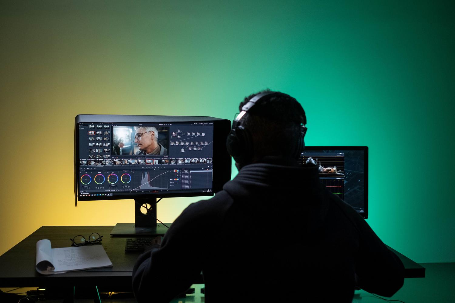 Editor de vídeo profesional con auriculares trabajando en la sincronización de pistas de audio en un monitor