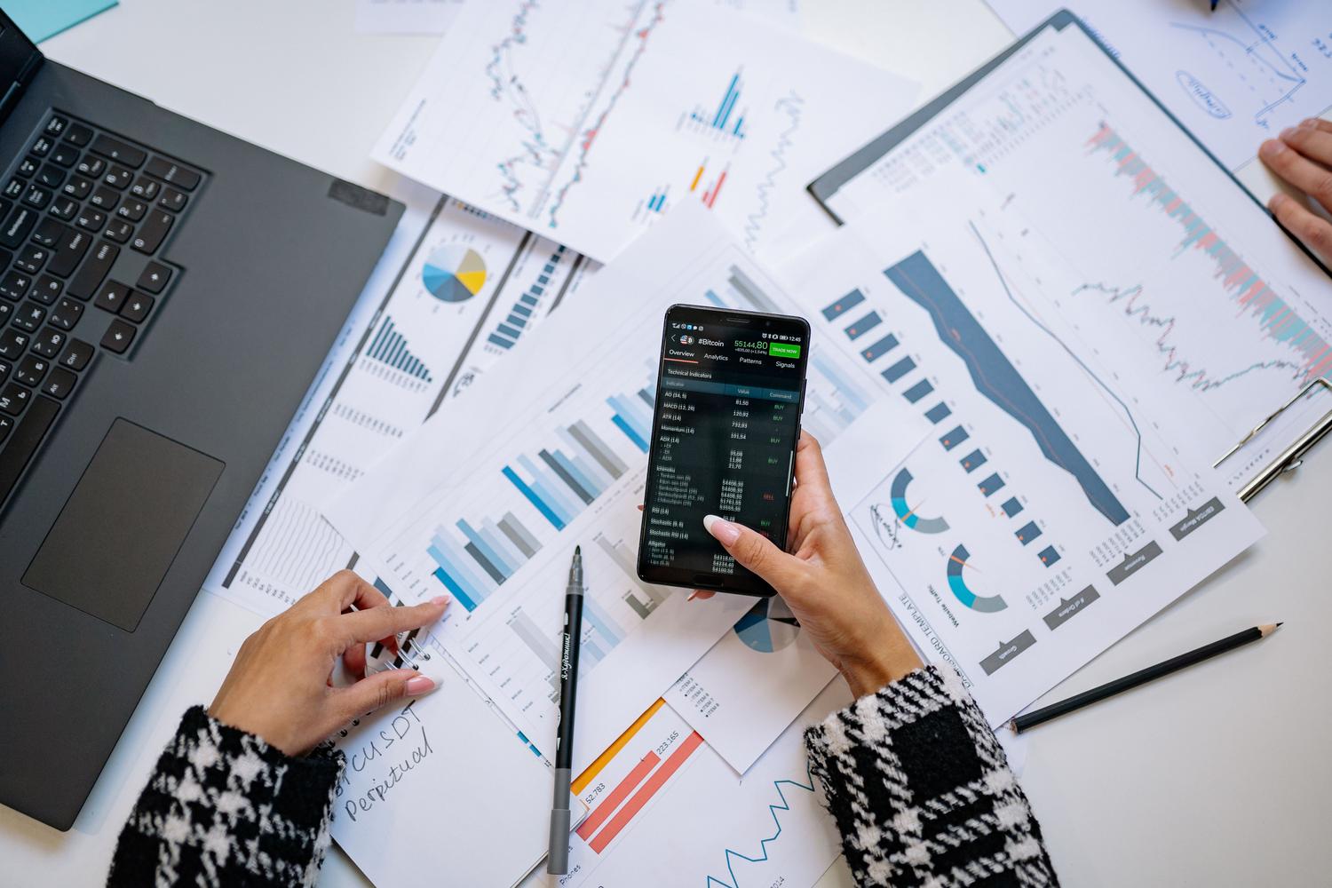 Vista cenital de un espacio de trabajo con smartphone y gráficos de datos, simbolizando una estrategia de Instagram Ads basada en datos.