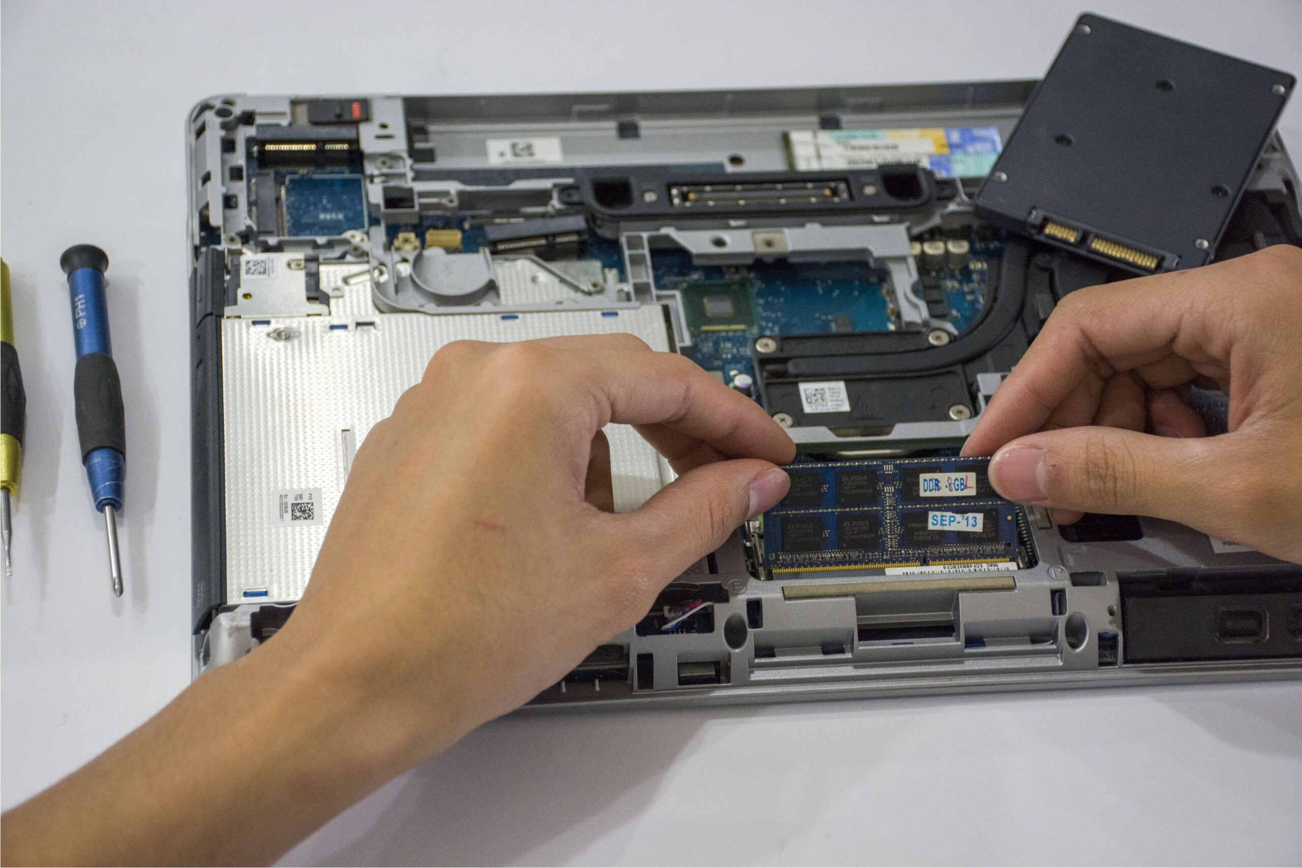 Técnico realizando mantenimiento interno de un ordenador portátil para actualizar componentes como el SSD.