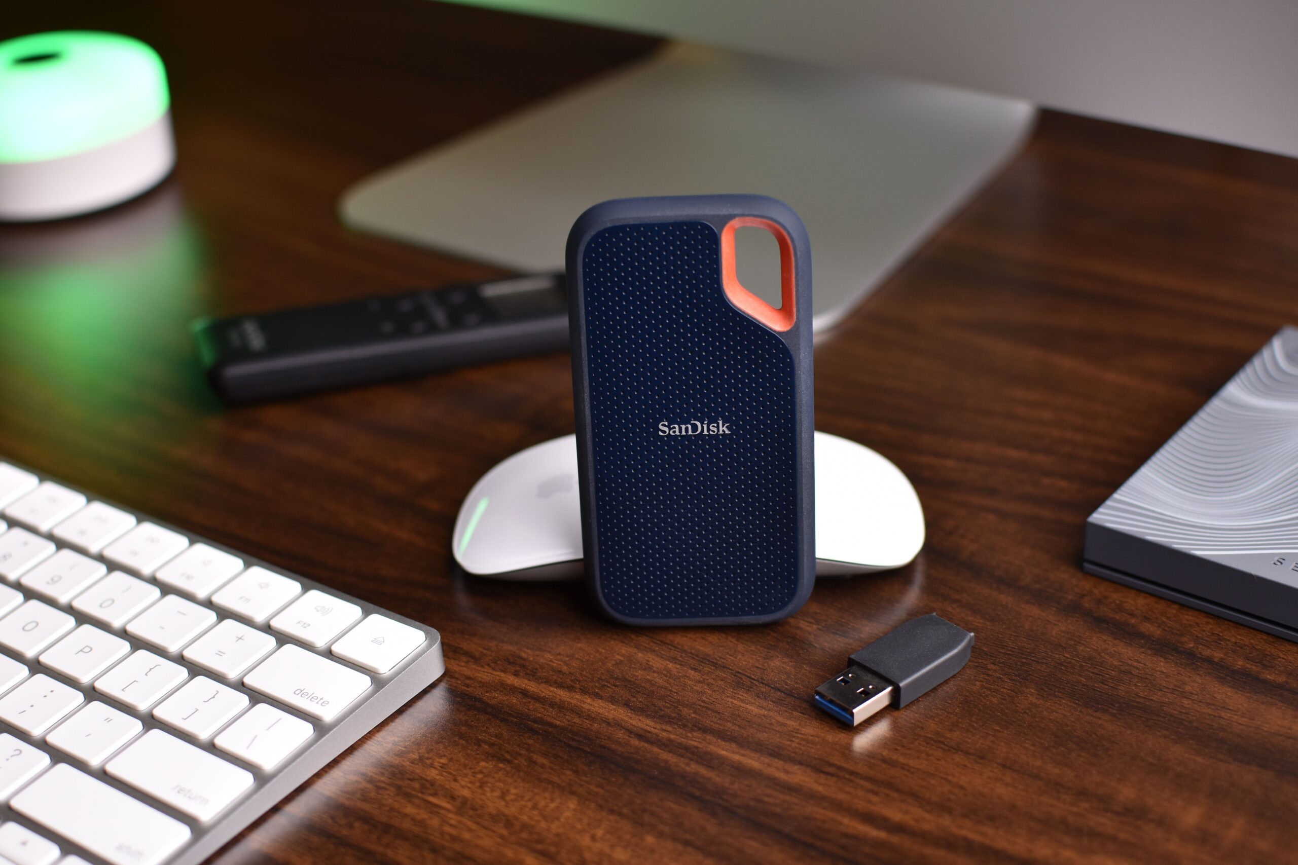 Escritorio de trabajo moderno y limpio con un SSD portátil SanDisk, proporcionando contexto de uso real.