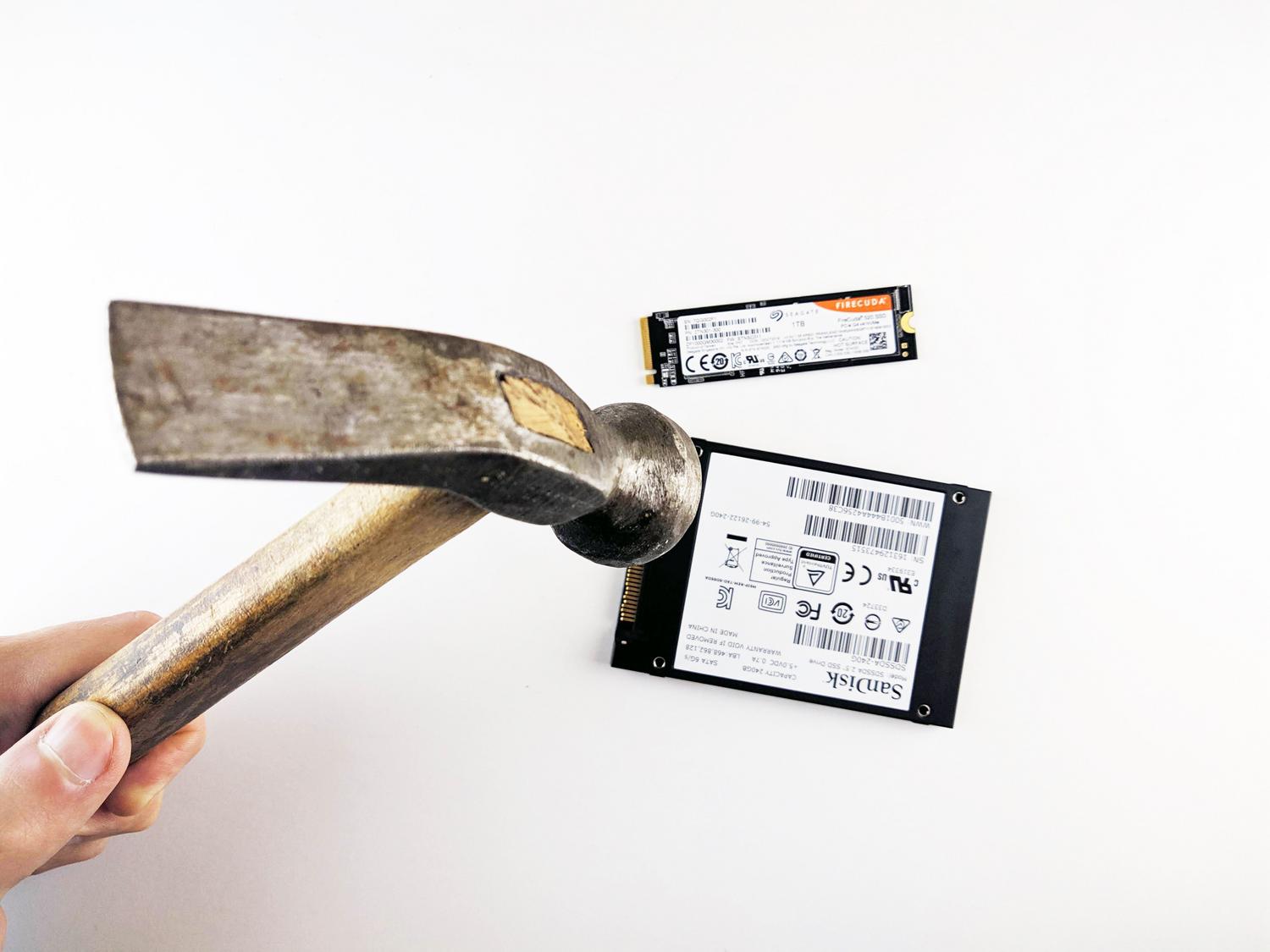 Imagen metafórica de un martillo a punto de golpear un SSD, representando el riesgo de pérdida total de datos por un fallo crítico.