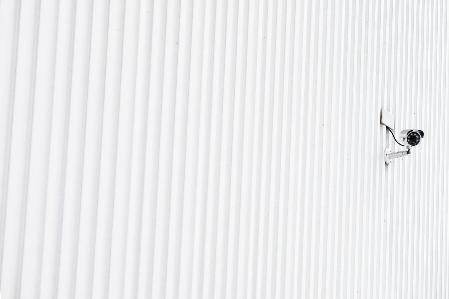 Cámara de seguridad IP minimalista montada en una pared blanca, representando la base de la videovigilancia moderna.