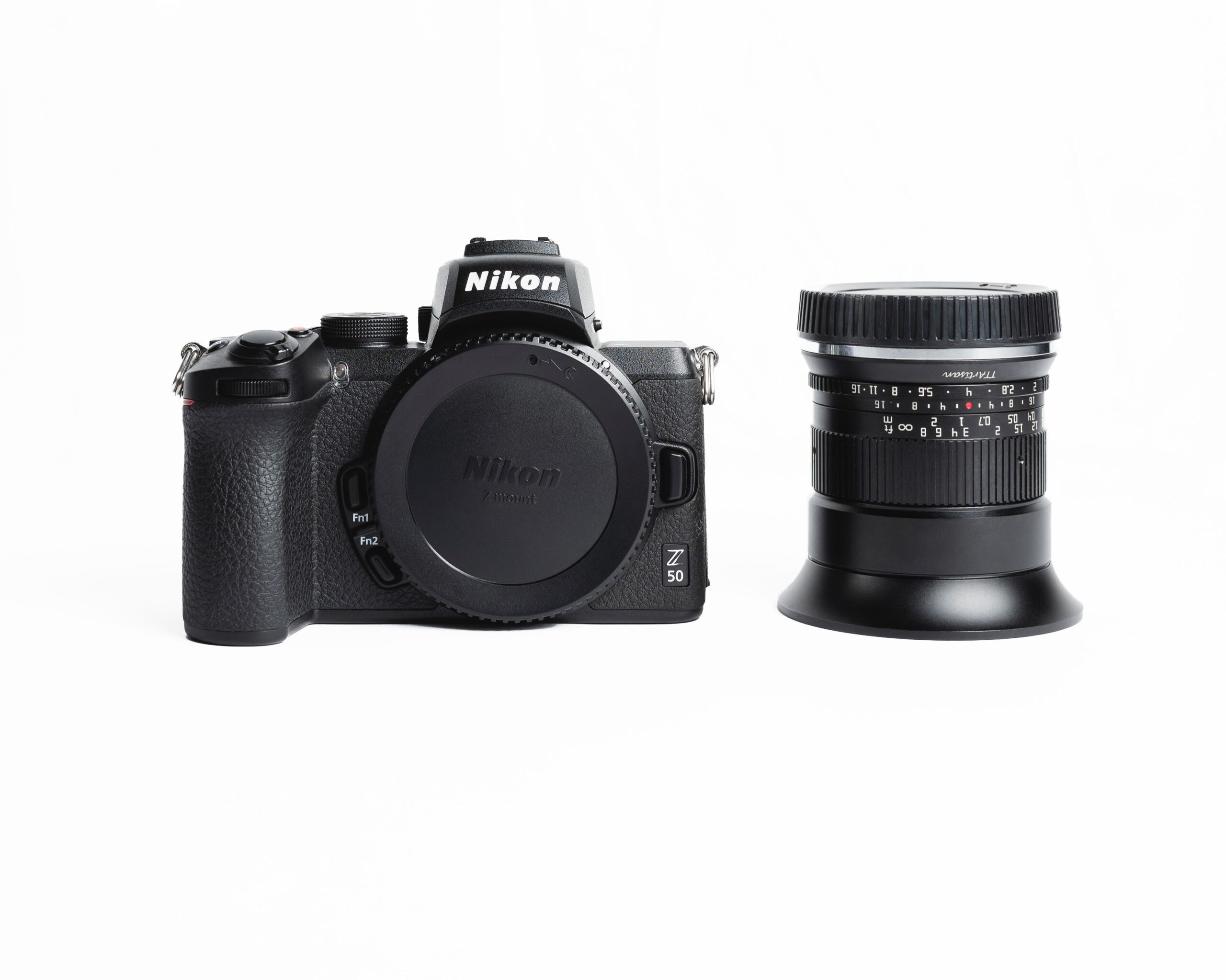 Vista minimalista de una cámara mirrorless Nikon Z50 sobre fondo blanco, ideal para una guía técnica de pasos para actualizar el sistema operativo.