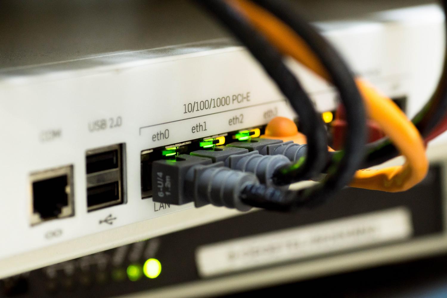 Primer plano de cables Ethernet conectados a un router, simbolizando la optimización de la conexión a internet.