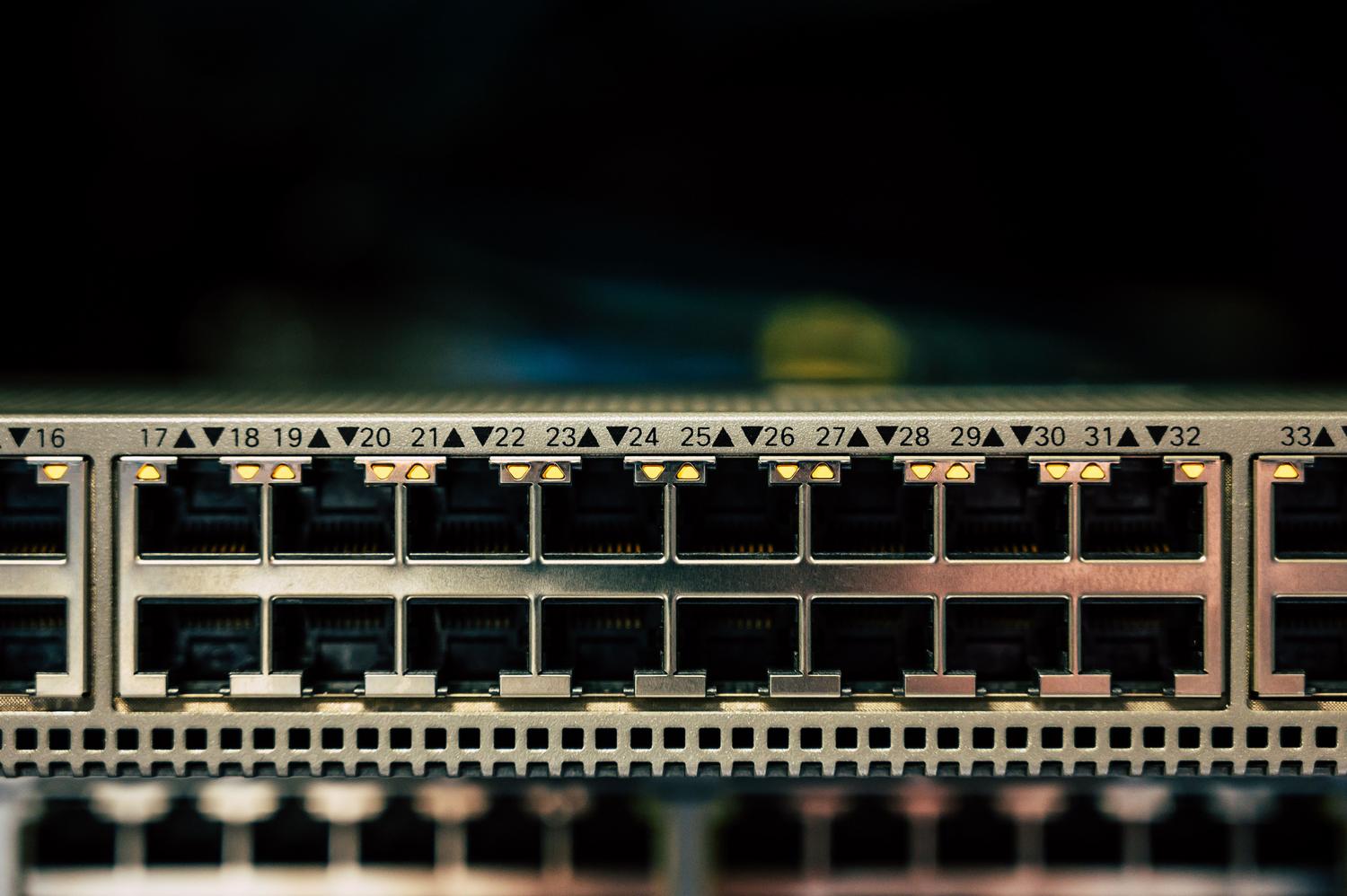 Detalle de un switch de red profesional con múltiples puertos y luces indicadoras, representando la transformación del router en una herramienta profesional.