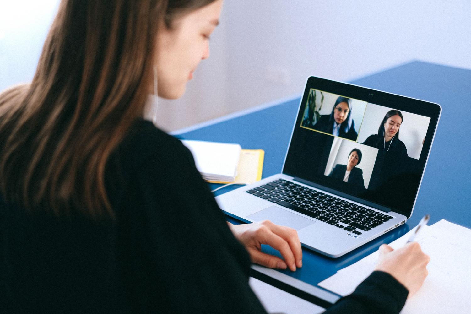 Mujer participando en una videoconferencia desde su hogar, destacando la necesidad de una conexión estable y priorizada.