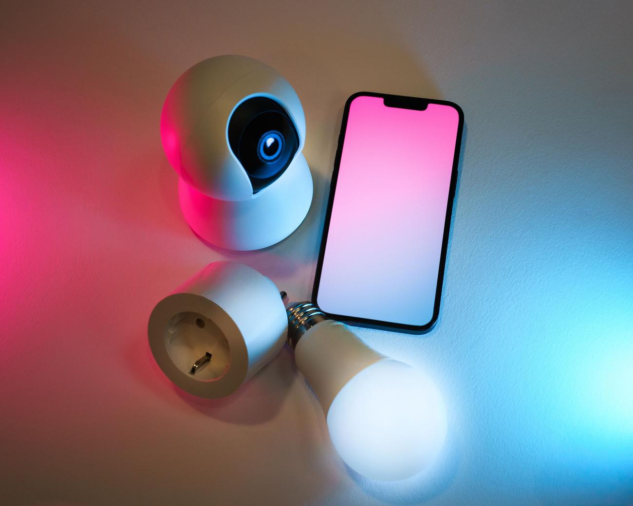Dispositivos de hogar inteligente IoT como cámaras y bombillas conectadas a una red WiFi.