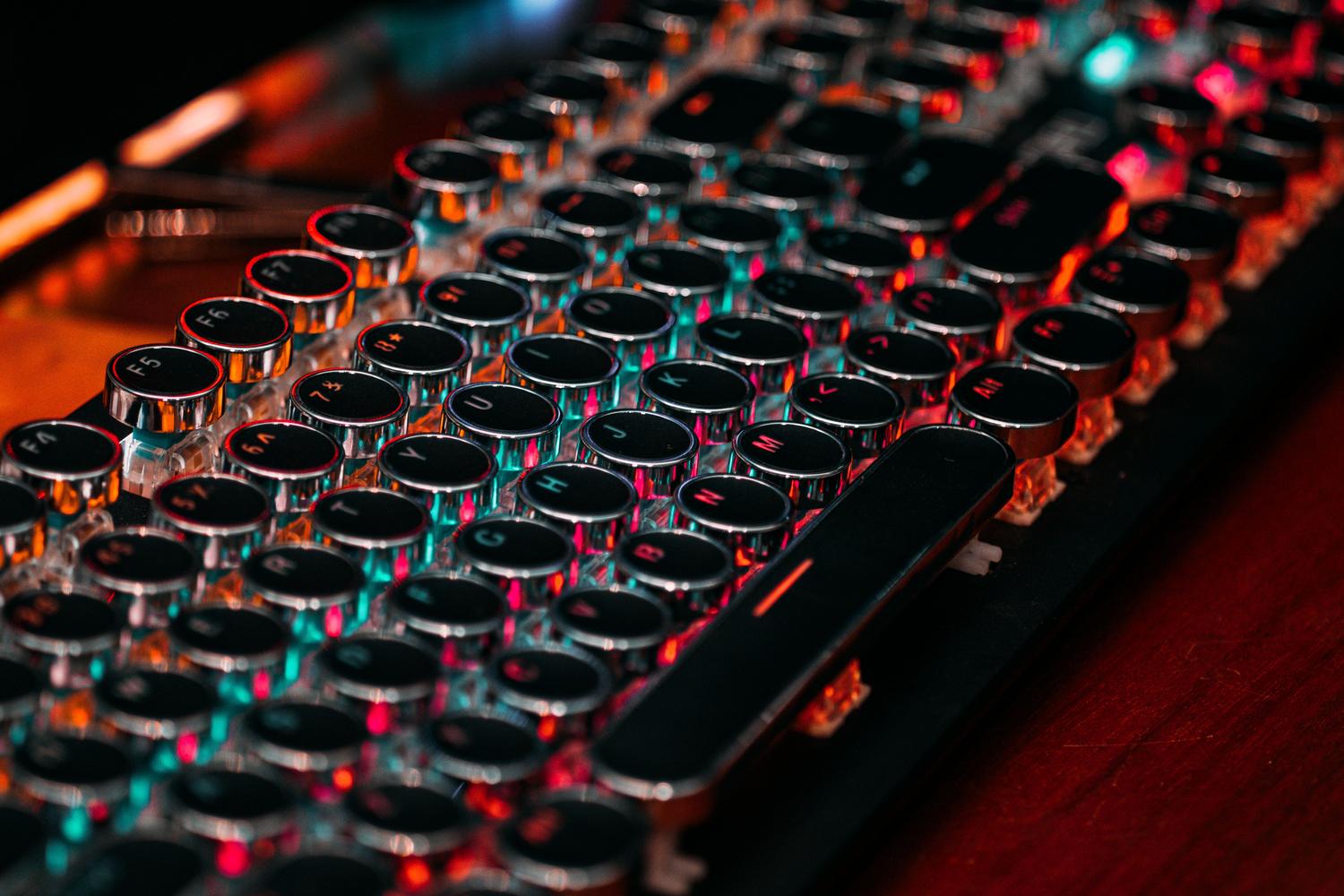 Teclado mecánico de estilo retro-futurista con teclas circulares e iluminación RGB vibrante, resaltando la estética de los teclados personalizados.