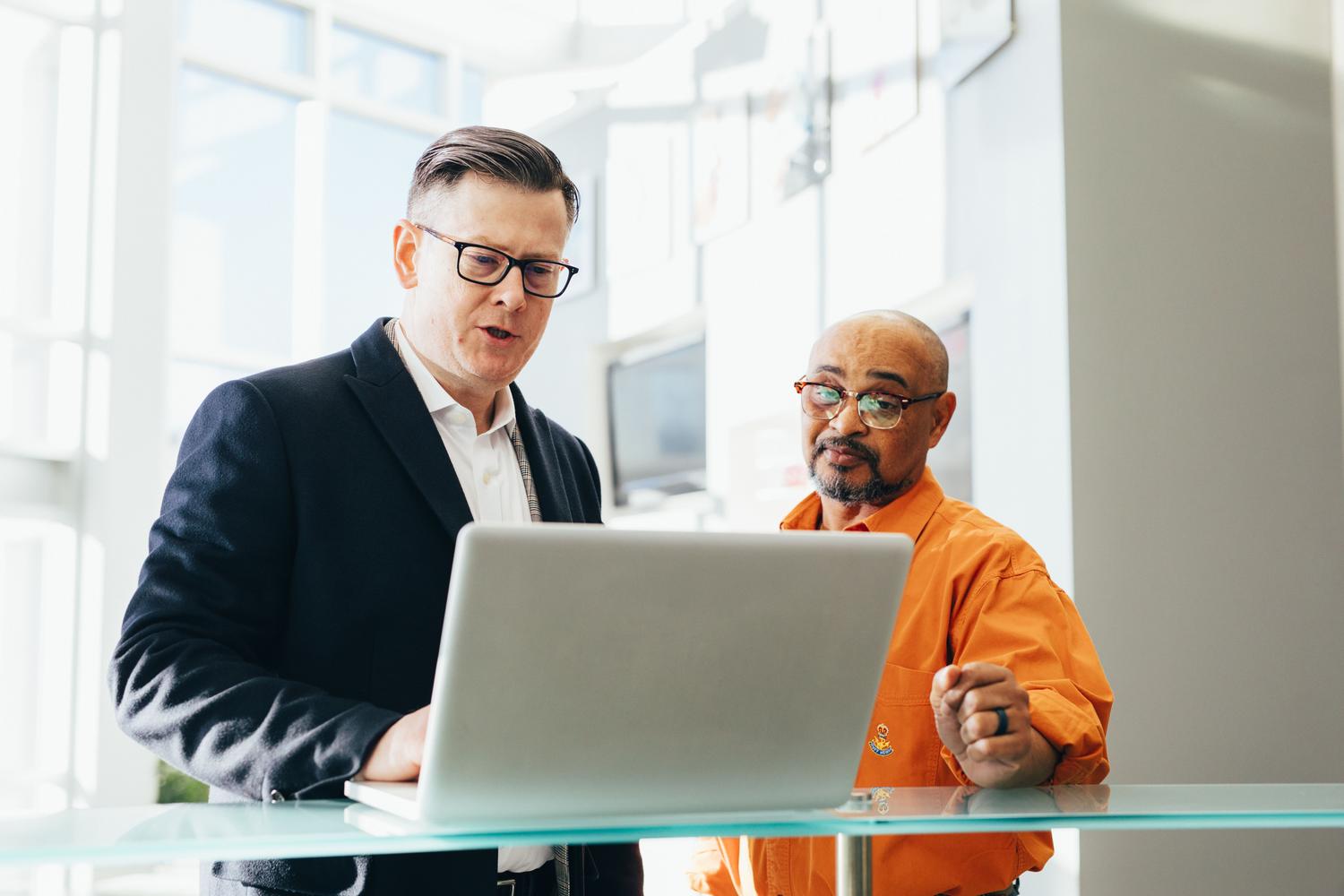 Dos profesionales analizando datos en un ordenador portátil en una oficina moderna, ilustrando la prospección estratégica con LinkedIn Sales Navigator.