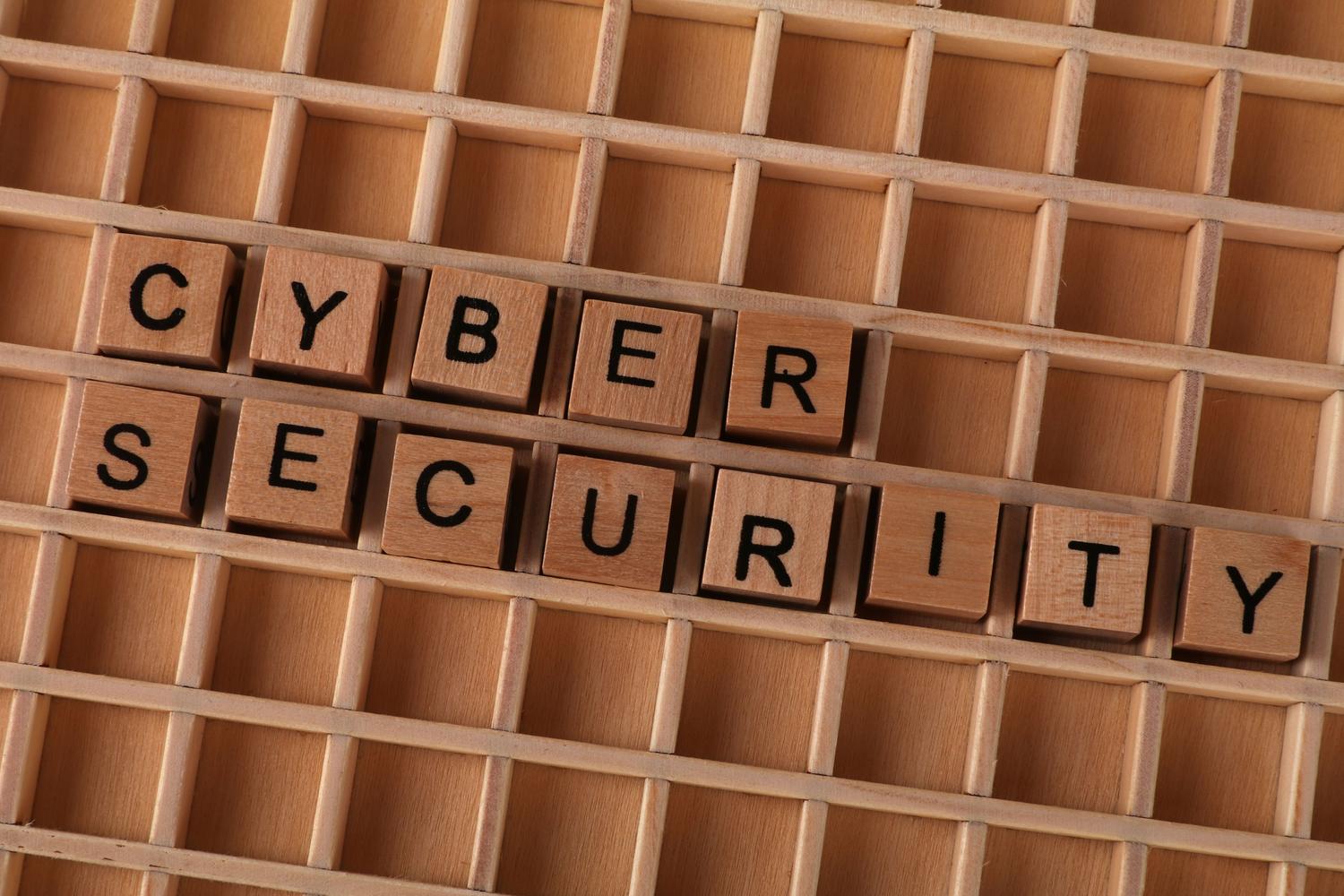 Letras de madera formando 'CYBER SECURITY', enfatizando la protección de datos clínicos frente a ciberataques.