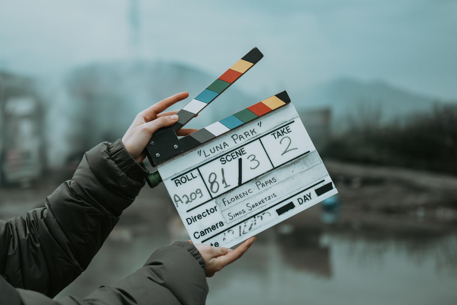 Una claqueta de cine profesional en un set, simbolizando la transición del guion escrito a la producción audiovisual.