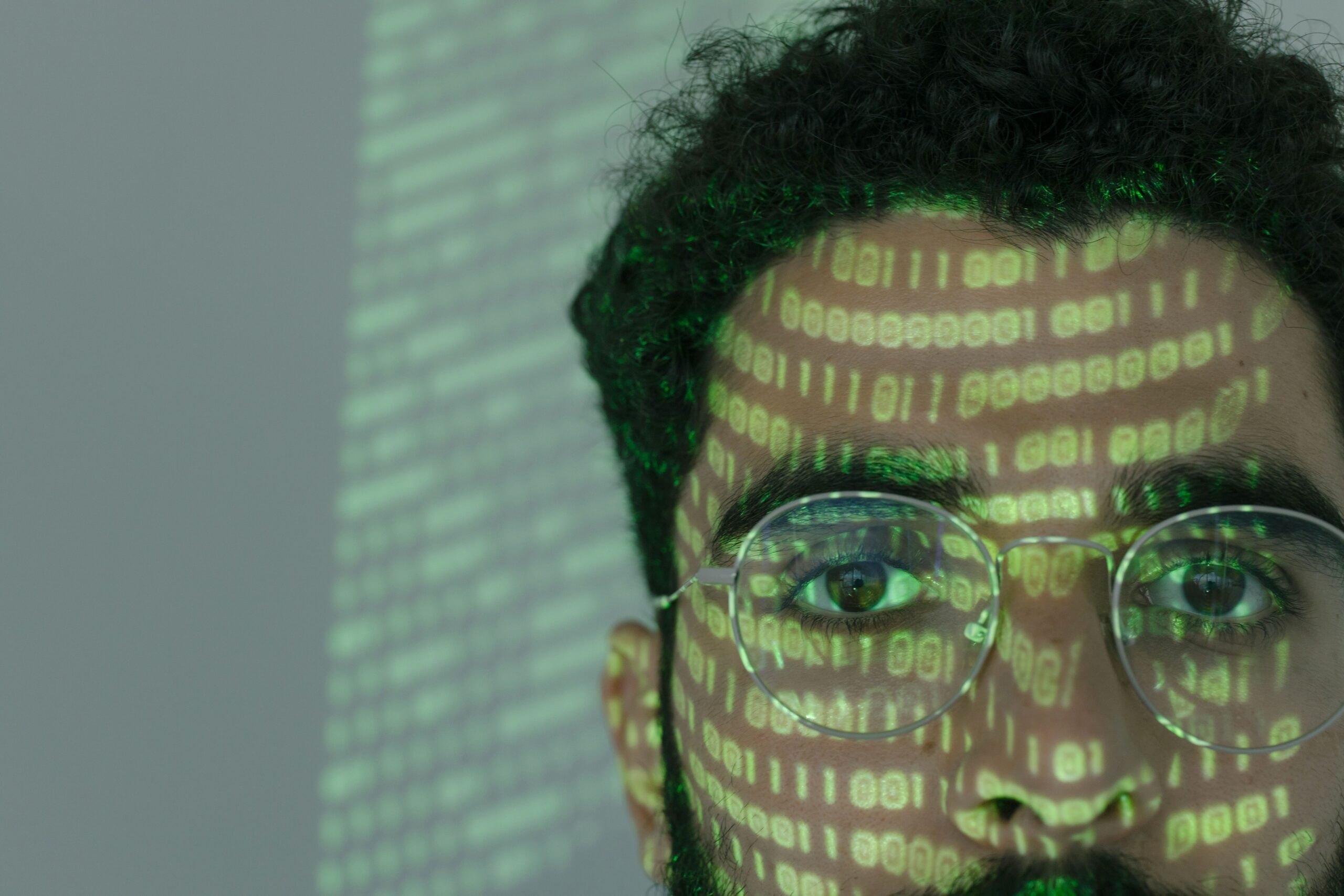 Representación conceptual de ciberseguridad financiera con código binario proyectado sobre un rostro.
