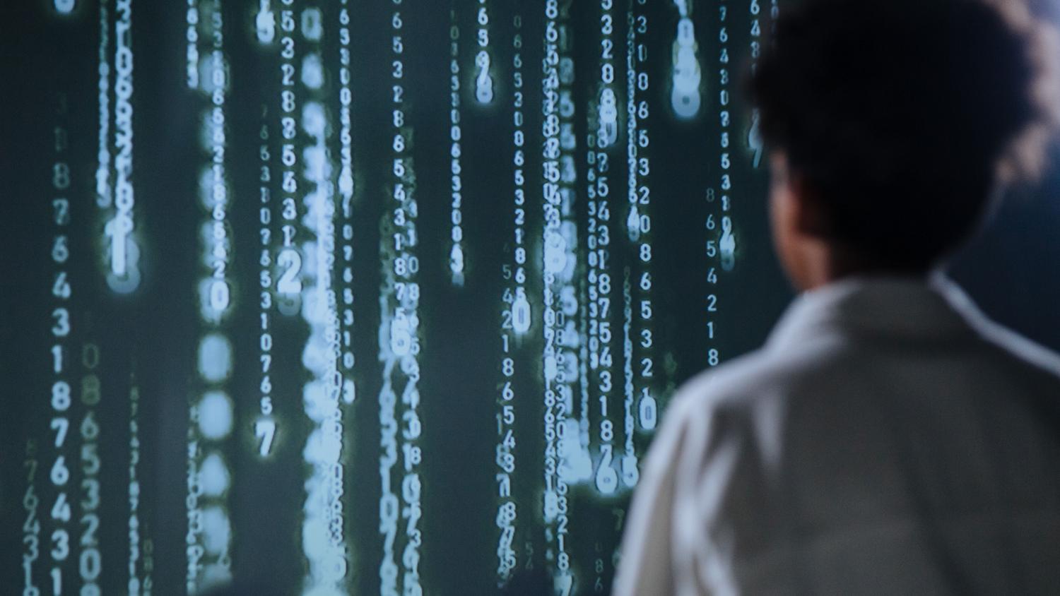 Persona interactuando con una pantalla de datos digitales, representando la complejidad y el procesamiento de la IA local.